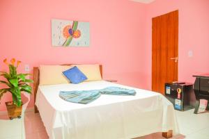 1 dormitorio con paredes rosas y 1 cama en Passarela do Caranguejo PB en Conde