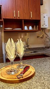 two wine glasses on a wooden tray on a counter at Pacifico Apart Hotel in Santa Cruz de la Sierra