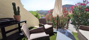 een balkon met stoelen en een cactus en bloemen bij les Issambres baie Saint Tropez appt standing 4 P in Les Issambres