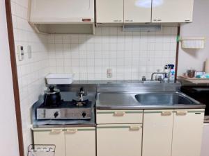 a kitchen with a sink and a stove at リバーサイド厚生町 in Okayama