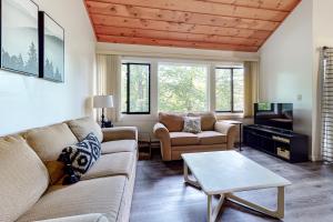 a living room with two couches and a tv at Loon Mountain Getaway in Lincoln