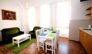 a kitchen with a table and chairs in a room at CentrÁlom Apartman in Pécs