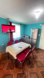 a kitchen with a table and chairs and a refrigerator at Cabañas Don Pedro in Coihaique