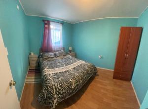 - une chambre avec un lit dans une pièce aux murs bleus dans l'établissement Cabañas Don Pedro, à Coyhaique