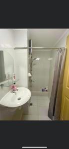a white bathroom with a sink and a shower at 2 Bedroom Condo Unit in Iloilo City