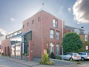 een bakstenen gebouw met auto's geparkeerd voor het bij Hotel Restaurant Esser in Wegberg