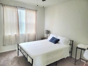 um quarto com uma cama branca e uma almofada azul em Phoenix Comfort home II em Phoenix