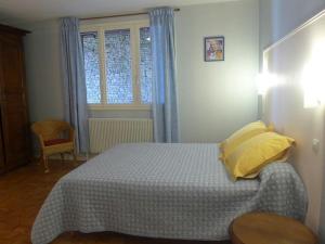 um quarto com uma cama com almofadas amarelas e uma janela em Gîte Aubepierre-sur-Aube, 3 pièces, 5 personnes - FR-1-611-52 