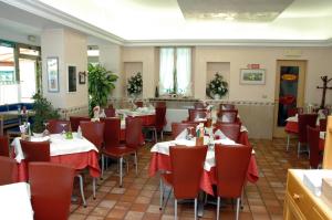 ein Esszimmer mit Tischen und roten Stühlen in der Unterkunft Hotel Da Angela in Sedegliano
