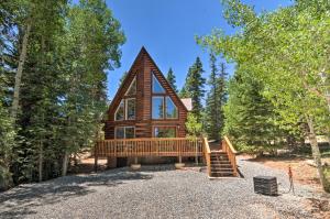 a large log cabin in the woods with a large deck at A-Frame Cabin Near Hiking and Biking Trails! in Duck Creek Village