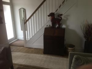 uma estátua de cão sentada em cima de uma cómoda numa sala de estar em Rose Cottage, Newbiggin-by-the-Sea em Woodhorn