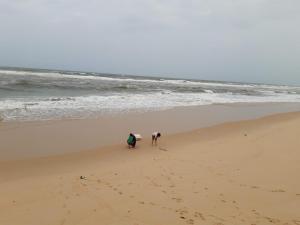 Dos personas caminando por la playa con una tabla de surf en Balaha en Ðồng Hới