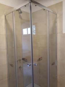 a shower with a glass door in a bathroom at cabañas La Victoria in La Falda