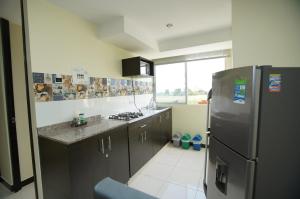 a kitchen with a stainless steel refrigerator and a window at Apartamento a 2km del Parque del Café in Montenegro