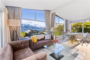 a living room with a couch and a table at Alpine Home with Amazing Mountain & Lake Views in Queenstown