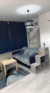een slaapkamer met een bed en een tafel. bij Appartement moderne refait à neuf proximité centre ville et plage in Coudekerque-Branche