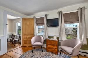 a living room with two chairs and a tv at Youngtown Inn in Youngtown