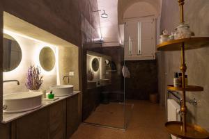 a bathroom with two sinks and two mirrors at Relais La Casa del Poeta in Gallipoli