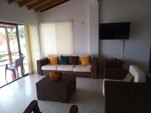 a living room with a couch and chairs and a television at Hermosa casa con la mejor vista cerca al Parque del Café in Montenegro