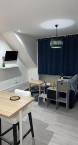 een woonkamer met een blauw gordijn en een tafel bij Appartement moderne refait à neuf proximité centre ville et plage in Coudekerque-Branche