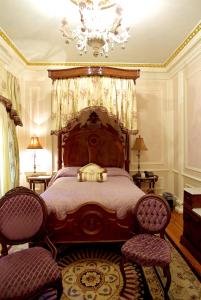 a bedroom with a large wooden bed with a chandelier at The Hotel Magnolia in Foley