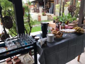 萨夸雷马Hostel Lagoa do Sol的一张黑桌,上面有食物和饮料