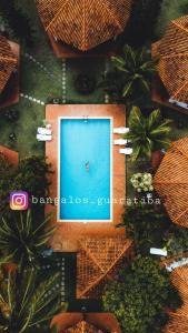 una vista aérea de una piscina con sombrillas en Bangalô 12 na praia de Guaratiba, Prado, ba en Prado