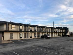 un bâtiment avec des voitures garées dans un parking dans l'établissement Hotel 7 Inn Paducah, à Paducah