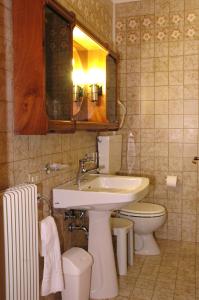 a bathroom with a sink and a toilet and a mirror at Hotel Da Angela in Sedegliano