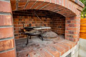 a brick oven with a pan and a pot at Villa Bianca in Blagaj