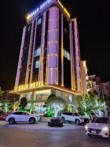 hotel z samochodami zaparkowanymi przed nim w nocy w obiekcie SALA HOTEL MÓNG CÁI w mieście Móng Cái