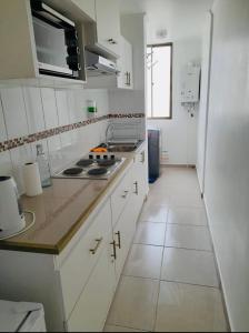 uma cozinha com armários brancos e uma bancada em Departamento Portal Caldera em Caldera
