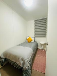 Dormitorio con cama con almohada amarilla en Departamento Portal Caldera, en Caldera
