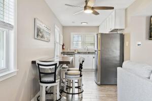 a kitchen with a stainless steel refrigerator and stools at Spectacular 3 BR Condo One Block to the Beach in Brigantine