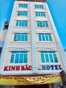 un edificio blanco con ventanas azules y un hotel con bolsas de kimbal en Kinh Bac Hotel Quy Nhon, en Quy Nhon