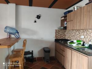 a kitchen with wooden cabinets and a counter top at Casa de descanso en marinilla in Marinilla