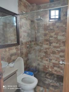 a bathroom with a toilet and a glass shower at Casa de descanso en marinilla in Marinilla