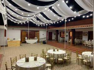 une salle de banquet avec des tables et des chaises blanches ainsi qu'une baignoire dans l'établissement Las Torrecitas, à Carhuaz