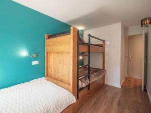 Un dormitorio con dos literas y una pared azul. en Charmant 2 pièces pour 5 pers avec balcon, service linge inclus ! - FR-1-291-877, en Valmorel