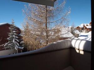 a view of a snow covered tree from a balcony at Appartement lumineux · Proche des pistes et commerces · WIFI Gratuit - FR-1-275-135 in La Rosière