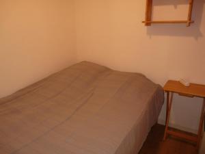 a small bed in a small room with a table at Appartement lumineux · Proche des pistes et commerces · WIFI Gratuit - FR-1-275-135 in La Rosière