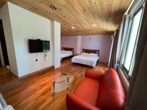 Una sala de estar con un sofá, una cama y un televisor. en 樂樂茶民宿, en Yung-an-ts'un