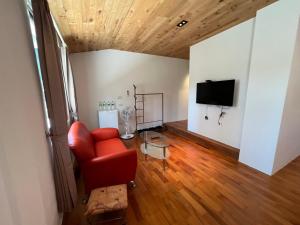 sala de estar con silla roja y TV en 樂樂茶民宿, en Yung-an-ts'un 12 fotos más