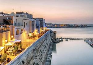 vista di una città di notte con l'acqua di Dody's Home a Otranto
