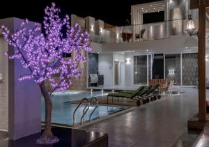 a house with a purple tree next to a swimming pool at ابهار vip in Jadīd