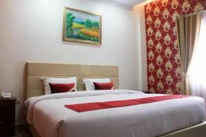 a bedroom with a large bed with a red blanket at Edotel Manggala Syariah RedPartner in Sudimara +21 photos