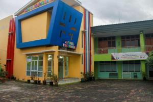 a colorful building with a large blue chair on it at Edotel Manggala Syariah RedPartner in Sudimara