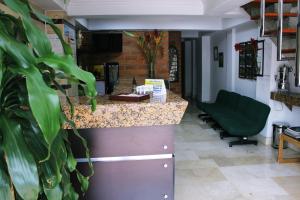 a bar in a waiting room with a green chair at Gran Caribe Hotel in Medellín