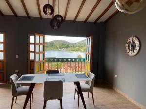a dining room with a table and a large window at Balcones de la pradera by Hope in Guatapé