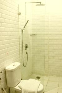 a bathroom with a toilet and a glass shower at White Tree Residence in Jakarta